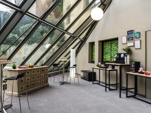 a room with windows and stools in a building at ibis Paris Alesia Montparnasse in Paris