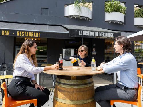 three women sitting at a table in front of a restaurant at ibis Bordeaux Centre Meriadeck in Bordeaux