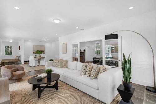a white living room with a white couch and a table at Memory Lane Cozy Home with Pool Lush South Miami in Miami