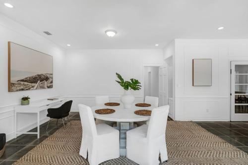 a white dining room with a table and chairs at Memory Lane Cozy Home with Pool Lush South Miami in Miami