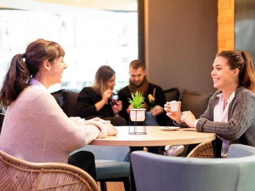 a group of people sitting around a table in a cafe at ibis Bordeaux Centre Meriadeck in Bordeaux