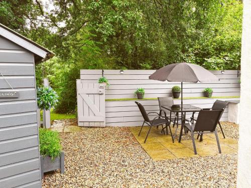 a table and chairs with an umbrella in a backyard at 2 Bed in Bude DBANK in Holsworthy