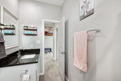 a white bathroom with a sink and a mirror at Modern Escape in Cedar Creek in Cedar Creek