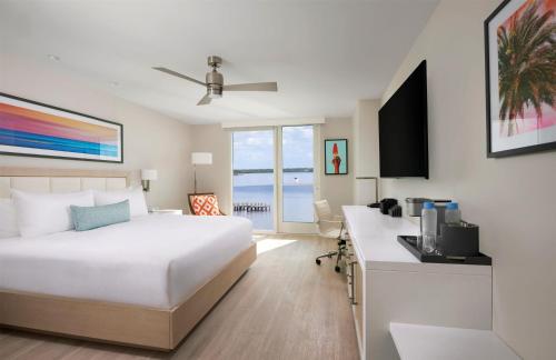 a bedroom with a bed and a desk with a kitchen at Sunseeker Resort Florida Gulf Coast, Curio Collection Hilton in Port Charlotte