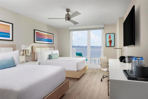 a hotel room with two beds and a desk at Sunseeker Resort Florida Gulf Coast, Curio Collection Hilton in Port Charlotte