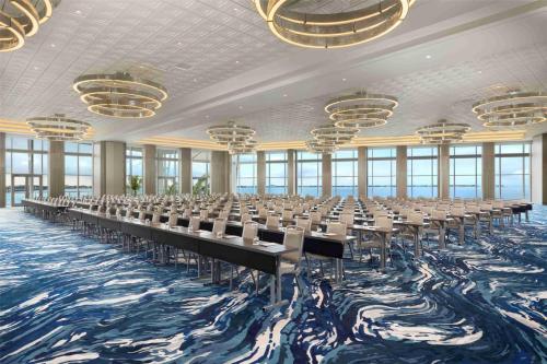 a conference room with tables and chairs on a blue carpet at Sunseeker Resort Florida Gulf Coast, Curio Collection Hilton in Port Charlotte