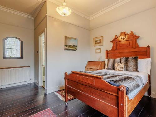 a bedroom with a large wooden bed in a room at 5 Bed in Dunkeld 90844 in Birnam