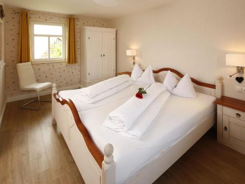 a bedroom with a large white bed with white pillows at One-bedroom apartment in Bernshausen