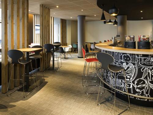 Un bar en un restaurante con sillas y mesas. en ibis Gent Centrum St. Baafs Kathedraal, en Gante