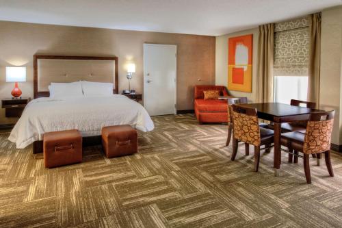 a hotel room with a bed and a table and chairs at Hampton Inn Corinth in Corinth