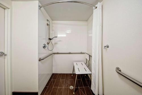 a bathroom with a shower and a bench in it at Hampton Inn Corinth in Corinth