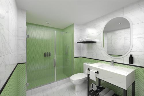 baño verde y blanco con aseo y lavamanos en Hilton Miami Beach, en Miami Beach