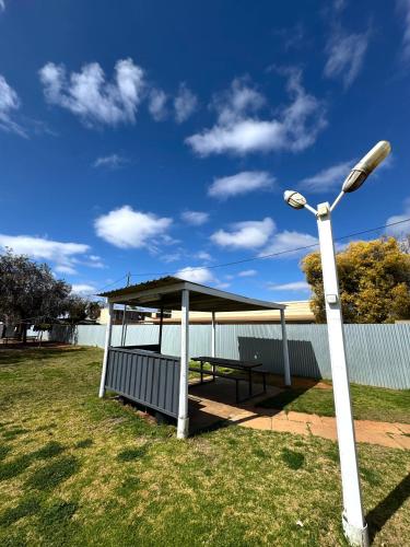 a picnic shelter with a street light next to it at Kalgoorlie Caravan Park in Kalgoorlie