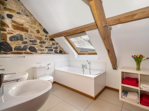 a bathroom with a white tub and a sink at 5 Bed in Dartmoor National Park 73264 in North Tawton