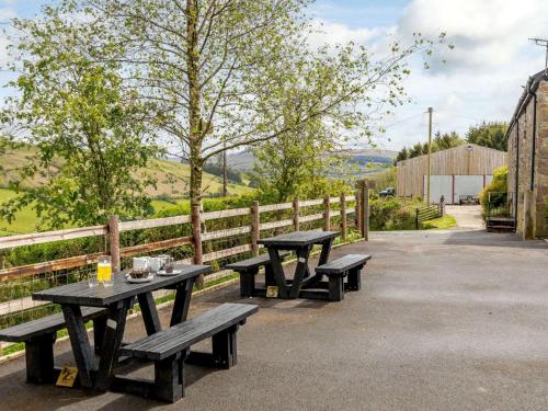 two picnic tables sitting next to a fence at 1 bed in Brecon BN034 in Cray