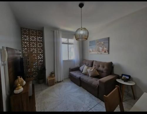 a living room with a couch and a window at Apartamento Praia do Morro in Guarapari
