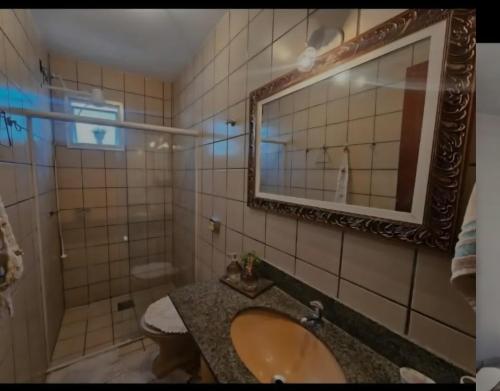 a bathroom with a sink and a mirror at Apartamento Praia do Morro in Guarapari
