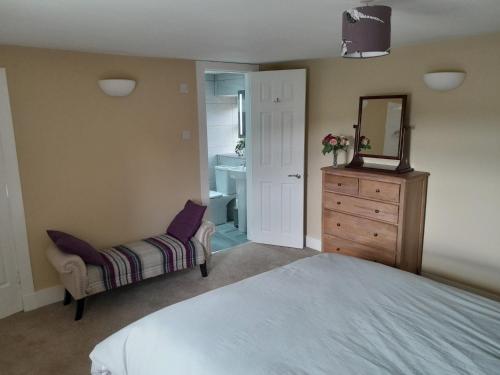 a bedroom with a bed and a mirror and a dresser at 3 Bed in The Cairngorms 53150 in Dinnet