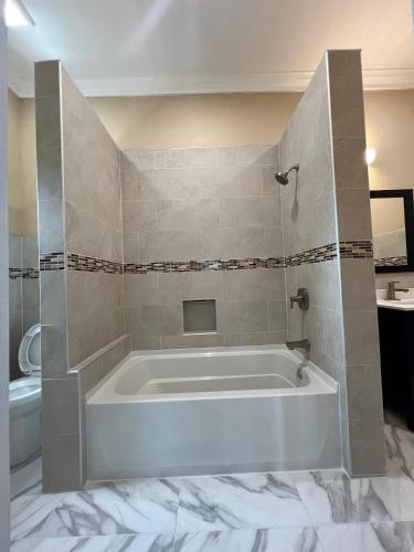 a white tub in a bathroom with a toilet at Tropical Palm Townhouse in Nassau