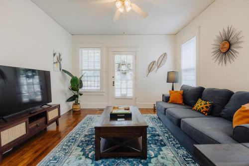 a living room with a blue couch and a tv at Historic Revival 2BR Midtown Memphis Fast Wifi Free Parking Yes Pets in Memphis