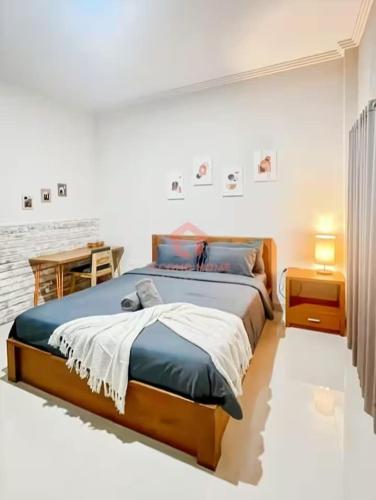 a bedroom with a large bed and a table at Uluwatu Guest House B Pool & Wifi in Uluwatu