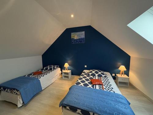 two beds in a attic bedroom with blue walls at Maison calme à Bransat, climatisée et avec jardin pour 6 personnes - FR-1-489-588 in Bransat