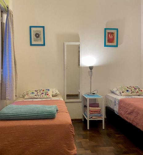 a room with two beds and a table with a lamp at Plazoleta Apartamento in Córdoba