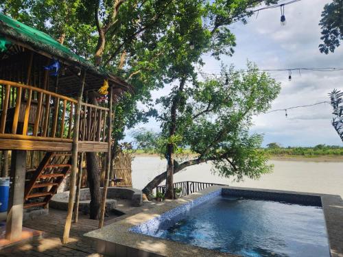 a house with a swimming pool next to a river at Mahogany Lane by KF in Arayat