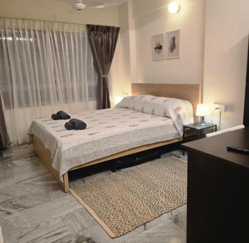 バンガロールにあるSuite 001のベッドと窓のある寝室