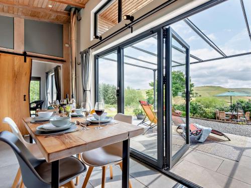 a dining room with a wooden table and glass doors at 2 Bed in Llandrindod Wells 53193 in Llandrindod Wells