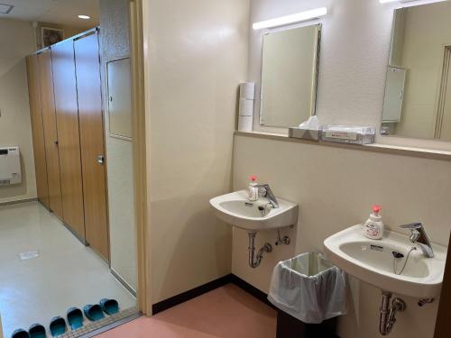 a bathroom with two sinks and a shower at 三陸アクティブ in Ōfunato