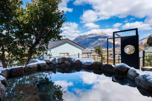 a pool with a mountain in the background at 小景緑b栋 免費接送免費停車 拥有私人露天溫泉 与由布岳四季对望 in Yufu