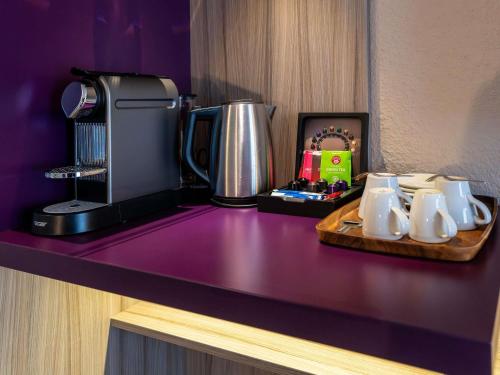 a table with a coffee maker and a tray of coffee mugs at Mercure Salzburg City in Salzburg