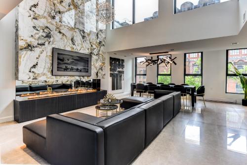 a lobby with black leather furniture and a wall of windows at CLUBHAUS Hotel in Montréal