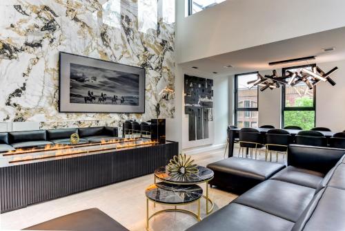 a lobby with black leather furniture and a stone wall at CLUBHAUS Hotel in Montréal