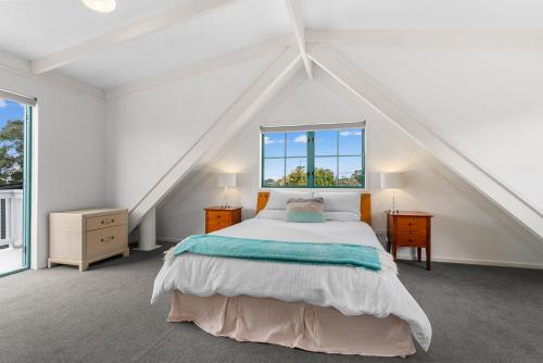 Waipu CoveにあるCove Family Haven - Waipu Holiday Homeのベッドと窓のある白い寝室