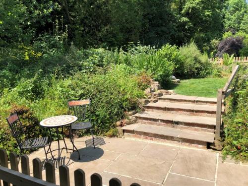 a garden with a table and chairs and stairs at 3 Bed in Fritchley 85797 in Crich