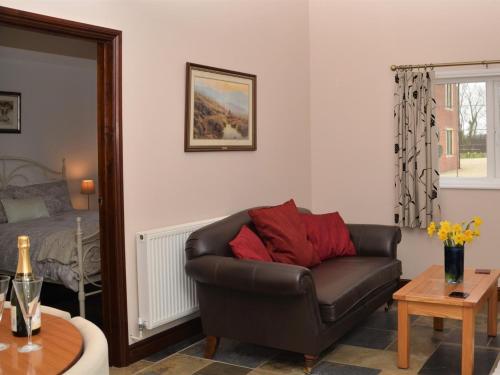 a living room with a leather couch and a bed at 1 bed in Bradford-on-Avon 58771 in Erlestoke