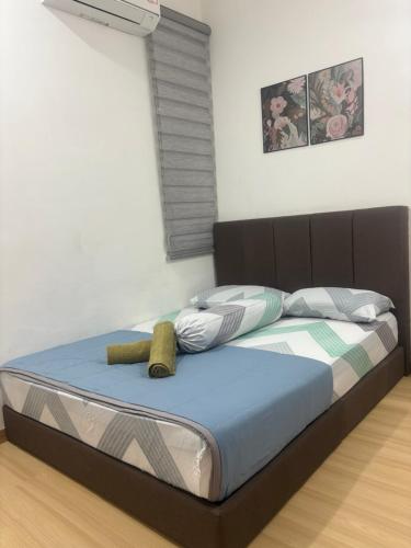 a bed with a brown headboard and pillows in a room at HoMestaY Kulim Seri Rambai in Kulim