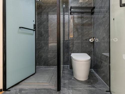 a bathroom with a toilet and a glass shower at 成都锦禧悦庭酒店宽窄巷子店 in Chengdu