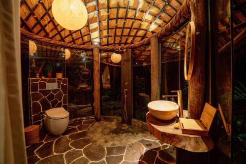 a bathroom with a toilet and a sink at Hideout Eco Bamboo House Bali in Selat