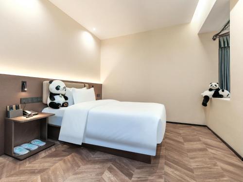 a bedroom with a bed with panda bears on it at 成都锦禧悦庭酒店宽窄巷子店 in Chengdu