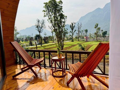 two chairs and a table on a balcony with a view at Phong Nha - Lèn Chùa Ecostay in Phong Nha