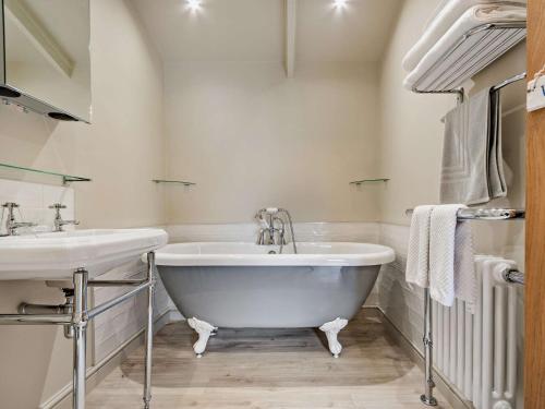 a white bathroom with a tub and a sink at 3 Bed in Melton Mowbray 61788 in Melton Mowbray