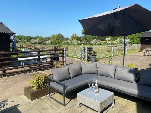 a couch and an umbrella on a patio at 3 Bed in Melton Mowbray 61788 in Melton Mowbray