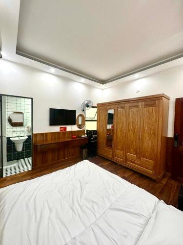 a bedroom with a large bed and a television at Mây Homestay in Quy Nhon