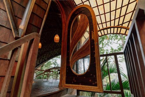 a mirror on the side of a building with a window at Hideout Eco Bamboo House Bali in Selat
