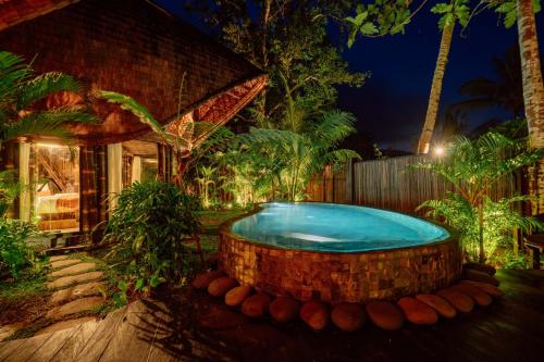 a swimming pool in the yard of a house at Hideout Eco Bamboo House Bali in Selat