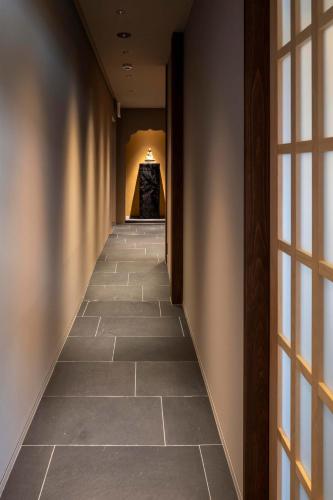 a hallway with a tile floor in a building at Momoyama Onsen Tsukimikan in Kyoto