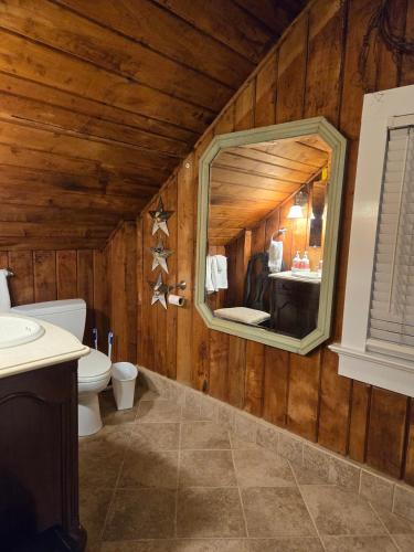 a bathroom with a mirror and a toilet and a sink at The Culpepper Inn in Elizabeth City